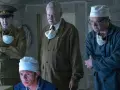 Mężczyźni w mundurach i fartuchach, w tym jeden w wojskowym, analizują coś na ekranie. Scena z serialu Czarnobyl Netflix.