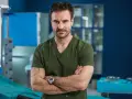 Dr. Witold w zielonym scrubie, z rękami skrzyżowanymi na piersi, w szpitalu św. Anny sezon 2.