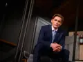 Filip Gurłacz w garniturze, siedzi na schodach, zastanawiając się, jaka to melodia.