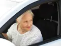 Starsza pani za kierownicą, rozgląda się, jakby zastanawiała się, co robimy podczas jazdy samochodem, może gra w Familiadę?