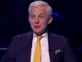 Prowadzący w garniturze z żółtym krawatem, jakby zapowiadał specjalne wydanie "Milionerzy Walentynki gdzie obejrzeć".
