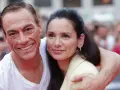 Jean-Claude Van Damme z uśmiechem obejmuje swoją żonę, Gladys Portugues, na tle tłumu.
