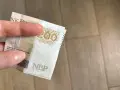 Dłoń trzyma banknot 200 zł. Gdzie można trzymać pieniądze? Familiada podpowie!