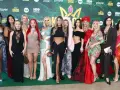 Królowe przetrwania 3 na premierze. Grupa kobiet w barwnych kreacjach pozuje na zielonym tle z logotypami wydarzenia.