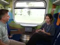 Rozmowa w wagonie z kolorowymi grafikami, być może w ramach specjalnego **metro programu** dla dzieci.