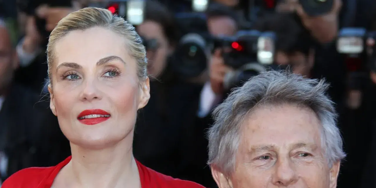 Emmanuelle Seigner, żona Romana Polańskiego, na czerwonym dywanie, otoczona przez fotoreporterów.