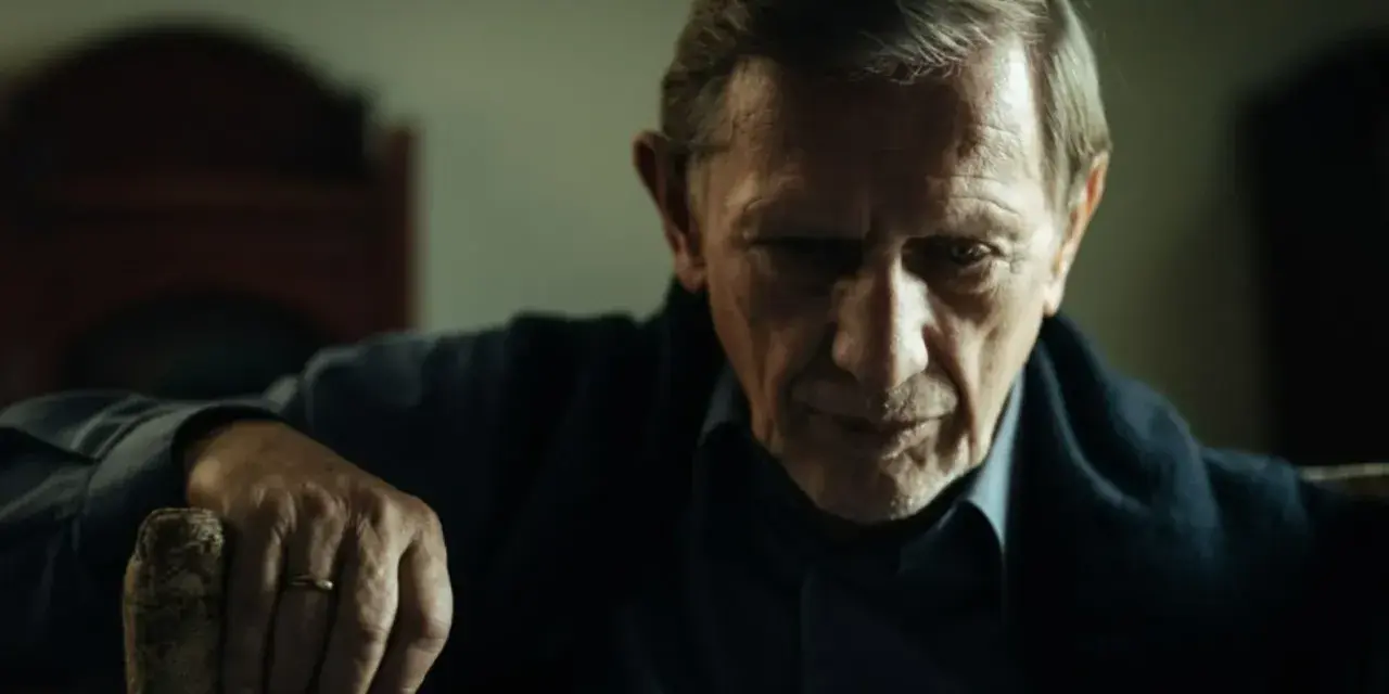 Jan Englert w filmach, zamyślony, z dłonią opartą o laskę.