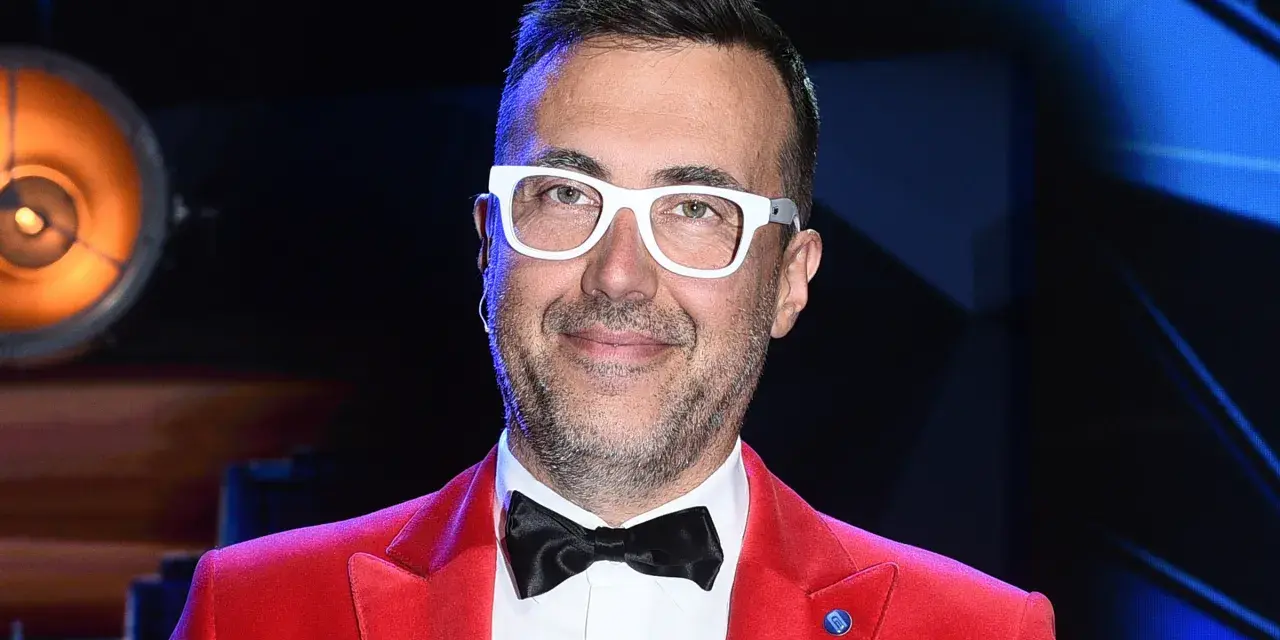 DJ z "Jaka to melodia?" w czerwonej marynarce i białych okularach, gotowy do zabawy.