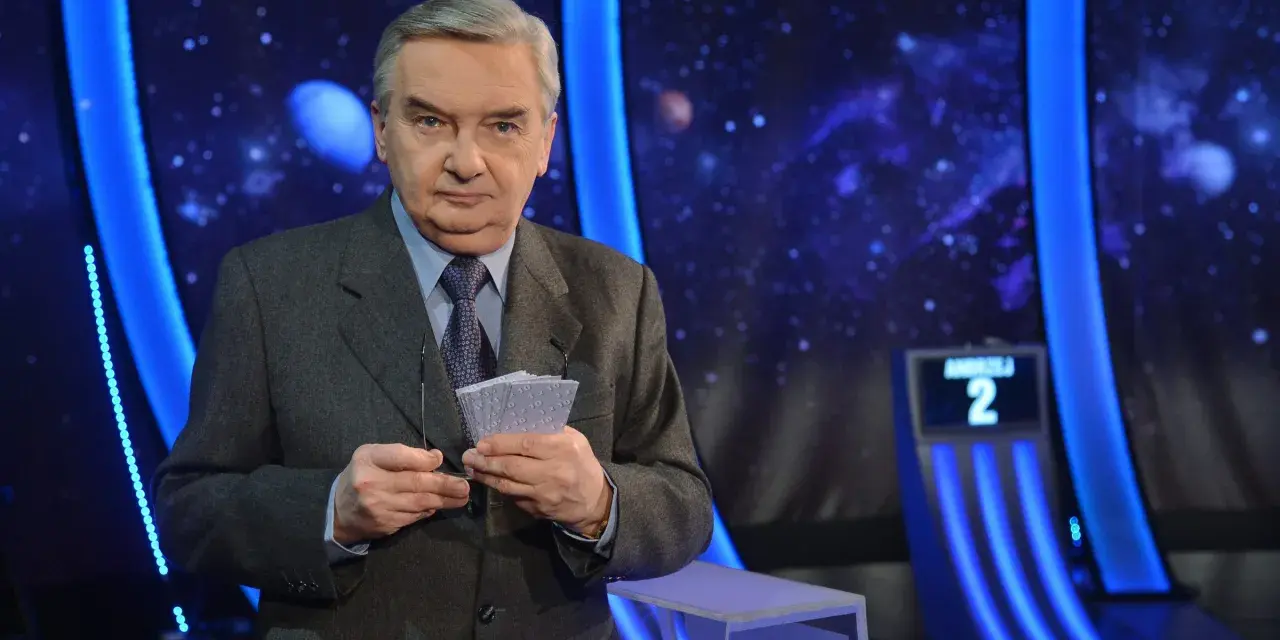 Tadeusz Sznuk, prowadzący Jeden z dziesięciu, trzyma karty z numerami.
