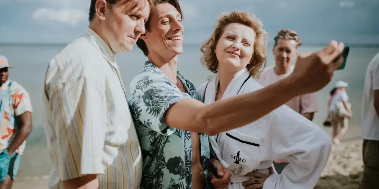 Trzech bohaterów z filmu "Teściowie 2" robi selfie na plaży. Gdzie obejrzeć ten hit?