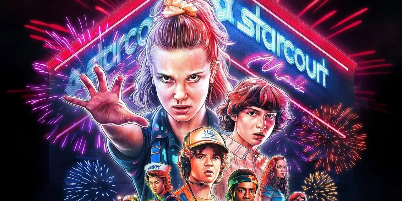 Eleven i jej przyjaciele z Stranger Things 3 gotowi do walki pod neonowym szyldem Starcourt Mall, otoczeni fajerwerkami.