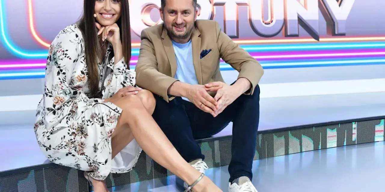 Uśmiechnięta prowadząca i Rafał Brzozowski, kto prowadzi Koło Fortuny, siedzą na scenie.