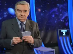 Tadeusz Sznuk, prowadzący Jeden z dziesięciu, trzyma karty z numerami.