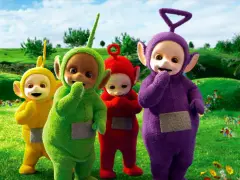 Teletubisie imiona: Tinky Winky, Dipsy, Laa-Laa i Po stoją na zielonej łące pełnej kwiatów.
