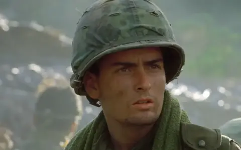 Charlie Sheen w wojskowym hełmie, jak w jego słynnych **filmach, serialach i programach**.