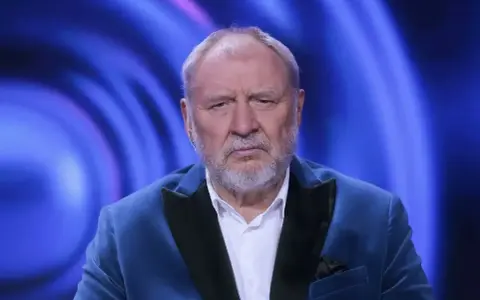 Andrzej Grabowski żyje i wygląda na zmęczonego, siedząc w niebieskiej marynarce na tle niebieskich świateł.