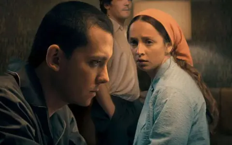 Trójka młodych ludzi wpatruje się w coś poza kadrem. Czy to scena z jednego z popularnych seriali Netflix?