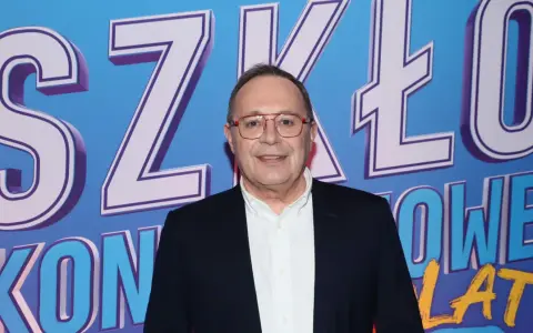 Uśmiechnięty mężczyzna w okularach na tle napisu "SZKŁO KONTAKTOWE OBSADA".