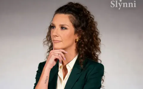Wiolka Walaszczyk, w wieku około 40 lat, w eleganckim zielonym żakiecie, zamyślona.