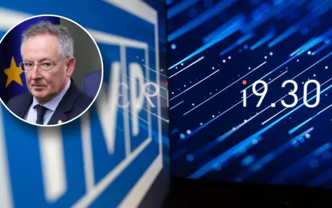 Mężczyzna w okularach na tle flagi UE, obok logo TVP w likwidacji i cyfrowego zegara 19:30.