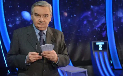 Tadeusz Sznuk, prowadzący Jeden z dziesięciu, trzyma karty z numerami.