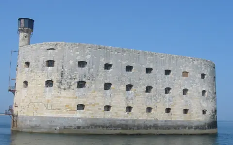Fort Boyard, imponująca kamienna twierdza na wodzie, z licznymi oknami i wieżą.