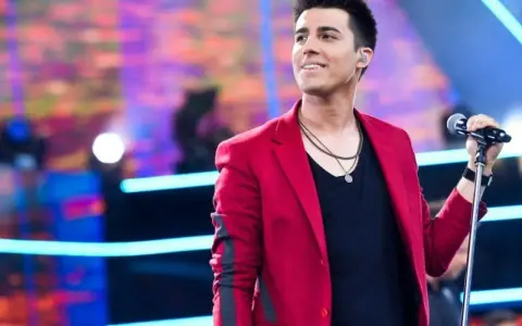 Filip śpiewa na scenie w czerwonej marynarce. Lato i jego żona pewnie są na widowni.