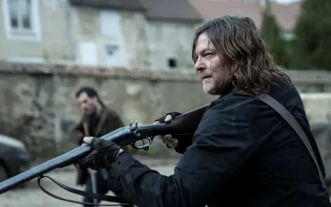 Daryl Dixon z sezonu 3, z blizną na twarzy, celuje z dwururki. W tle inny mężczyzna.