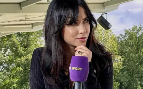 Maja Strzelczyk z mikrofonem Polsat Sport, w otoczeniu zieleni, przygotowuje się do wywiadu.