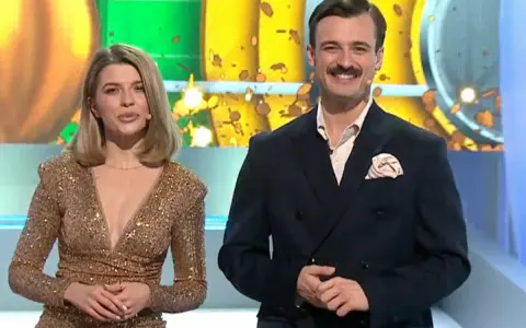 Para prowadzących w studio, ona w złotej sukni, on w garniturze. Czy to złota karta koło fortuny co to znaczy?