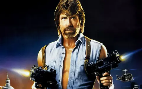 Chuck Norris z karabinami w akcji, jak w jego najlepszych filmach. W tle helikoptery i budynek.