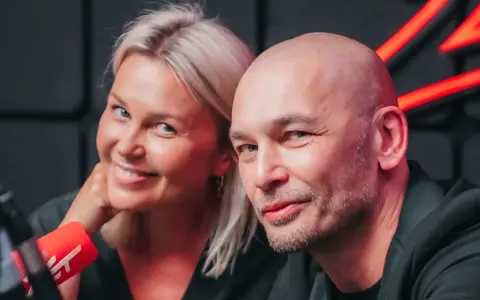 Tomasz Wygoda z żoną i dziećmi, uśmiechnięci przed mikrofonem.