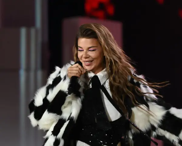 Edyta Górniak w szachownicznym futrze, z różowym makijażem oczu, śpiewa na scenie. Pamiętny występ na Eurowizji.