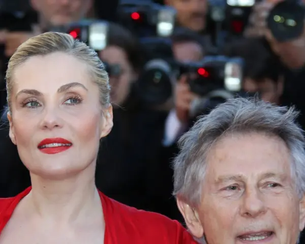 Emmanuelle Seigner, żona Romana Polańskiego, na czerwonym dywanie, otoczona przez fotoreporterów.