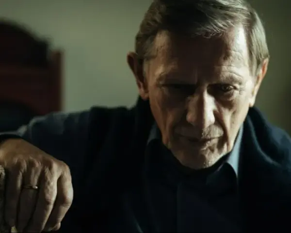 Jan Englert w filmach, zamyślony, z dłonią opartą o laskę.