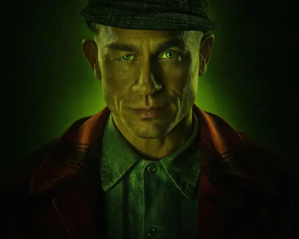 Mężczyzna z zielonymi oczami i czapką na głowie, w tle zielona poświata. Zapowiada mroczne seriale kryminalne Netflix.