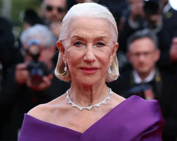 Helen Mirren w fioletowej sukni, olśniewająca na czerwonym dywanie. Jej bogata kariera obejmuje niezliczone filmy, seriale i programy.