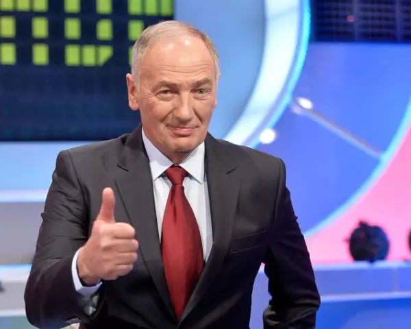 Uśmiechnięty mężczyzna w garniturze pokazuje kciuk w górę. Czy to znak, że wspólnie rozwiążemy Familiadę?
