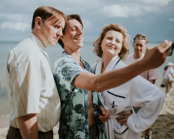 Trzech bohaterów z filmu "Teściowie 2" robi selfie na plaży. Gdzie obejrzeć ten hit?