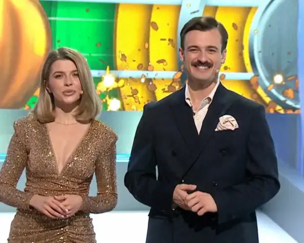 Para prowadzących w studio, ona w złotej sukni, on w garniturze. Czy to złota karta koło fortuny co to znaczy?