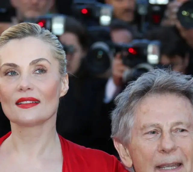 Emmanuelle Seigner, żona Romana Polańskiego, na czerwonym dywanie, otoczona przez fotoreporterów.