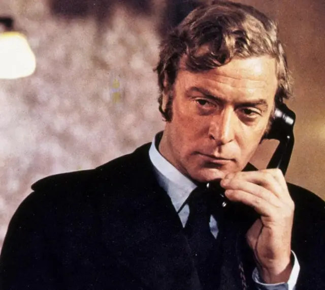 Michael Caine w jednym ze swoich kultowych filmów, rozmawia przez telefon.