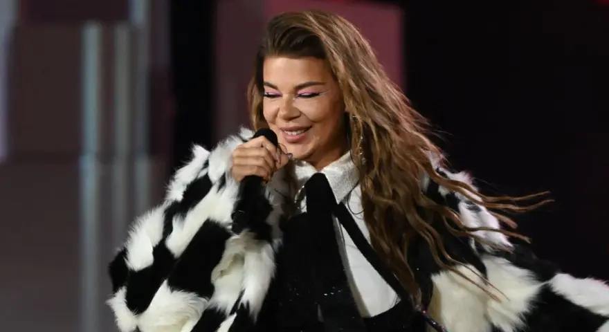 Edyta Górniak w szachownicznym futrze, z różowym makijażem oczu, śpiewa na scenie. Pamiętny występ na Eurowizji.