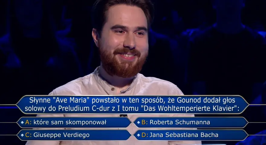 Uśmiechnięty uczestnik w programie Milionerzy zastanawia się, gdzie jest błąd w pytaniu o "Ave Maria" Gounoda.