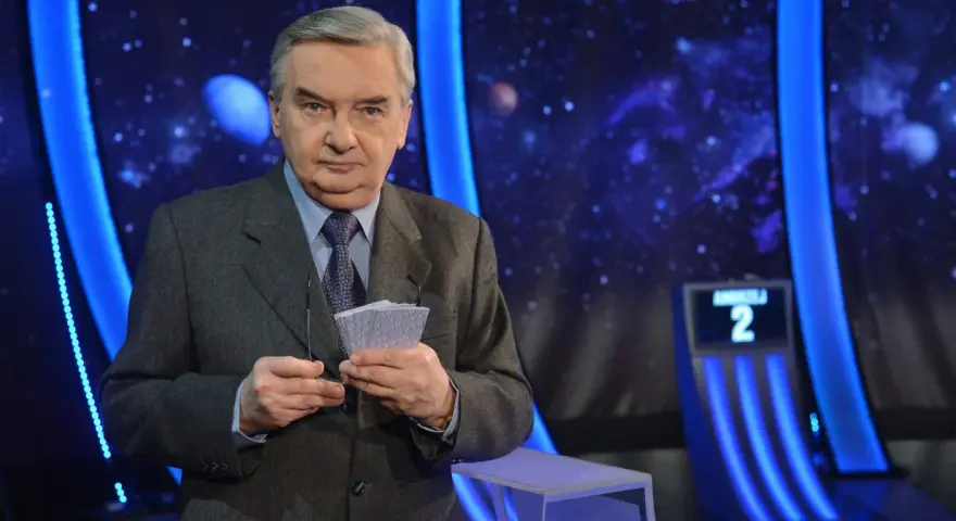 Tadeusz Sznuk, prowadzący Jeden z dziesięciu, trzyma karty z numerami.