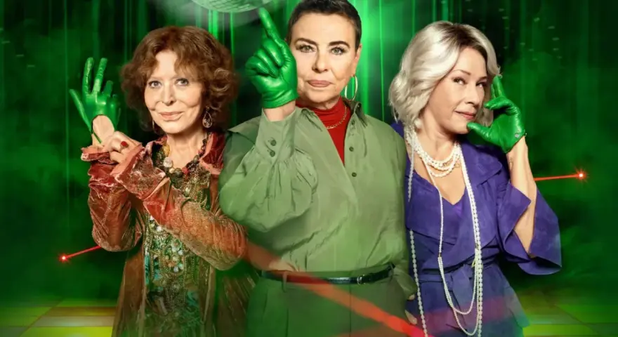 Gang zielonej rękawiczki: trzy kobiety w kolorowych strojach i zielonych rękawiczkach pozują na tle dyskotekowej kuli i zielonych świateł.