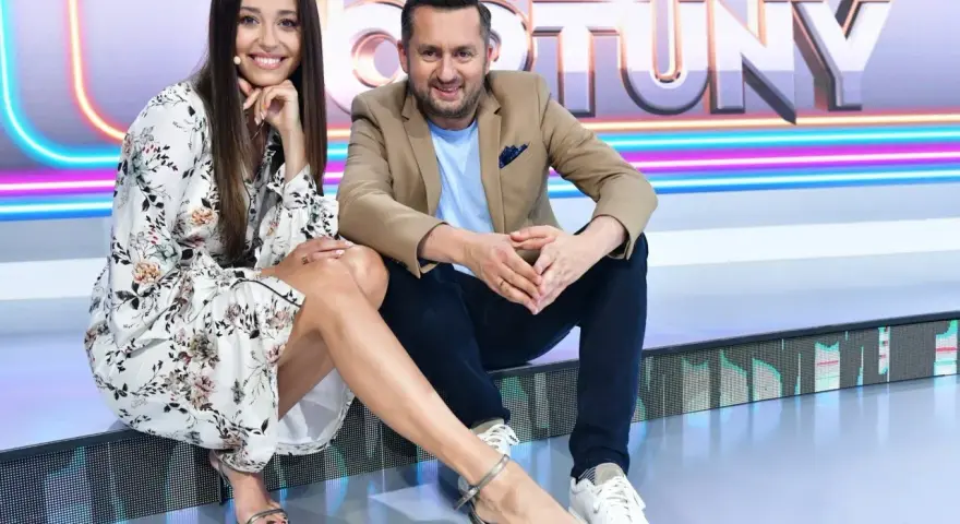 Uśmiechnięta prowadząca i Rafał Brzozowski, kto prowadzi Koło Fortuny, siedzą na scenie.