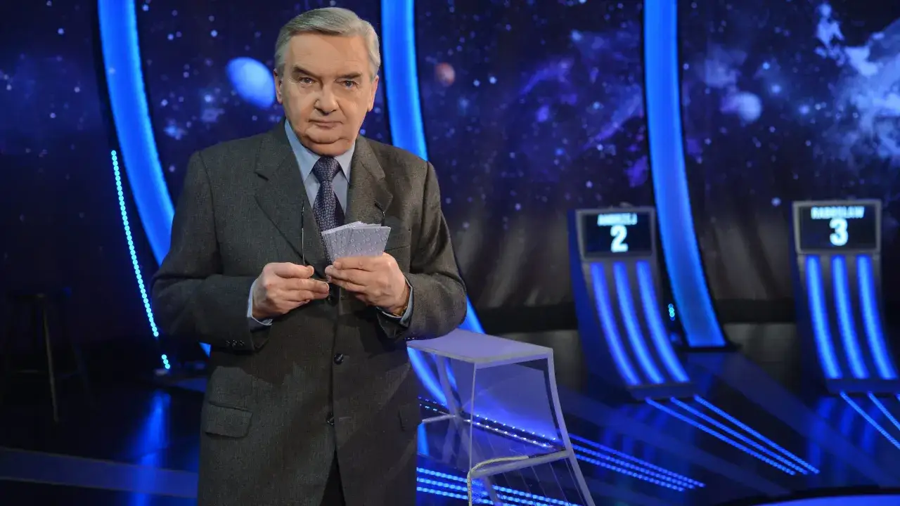 Stars and planets w tle, prowadzący trzyma karty z napisem 