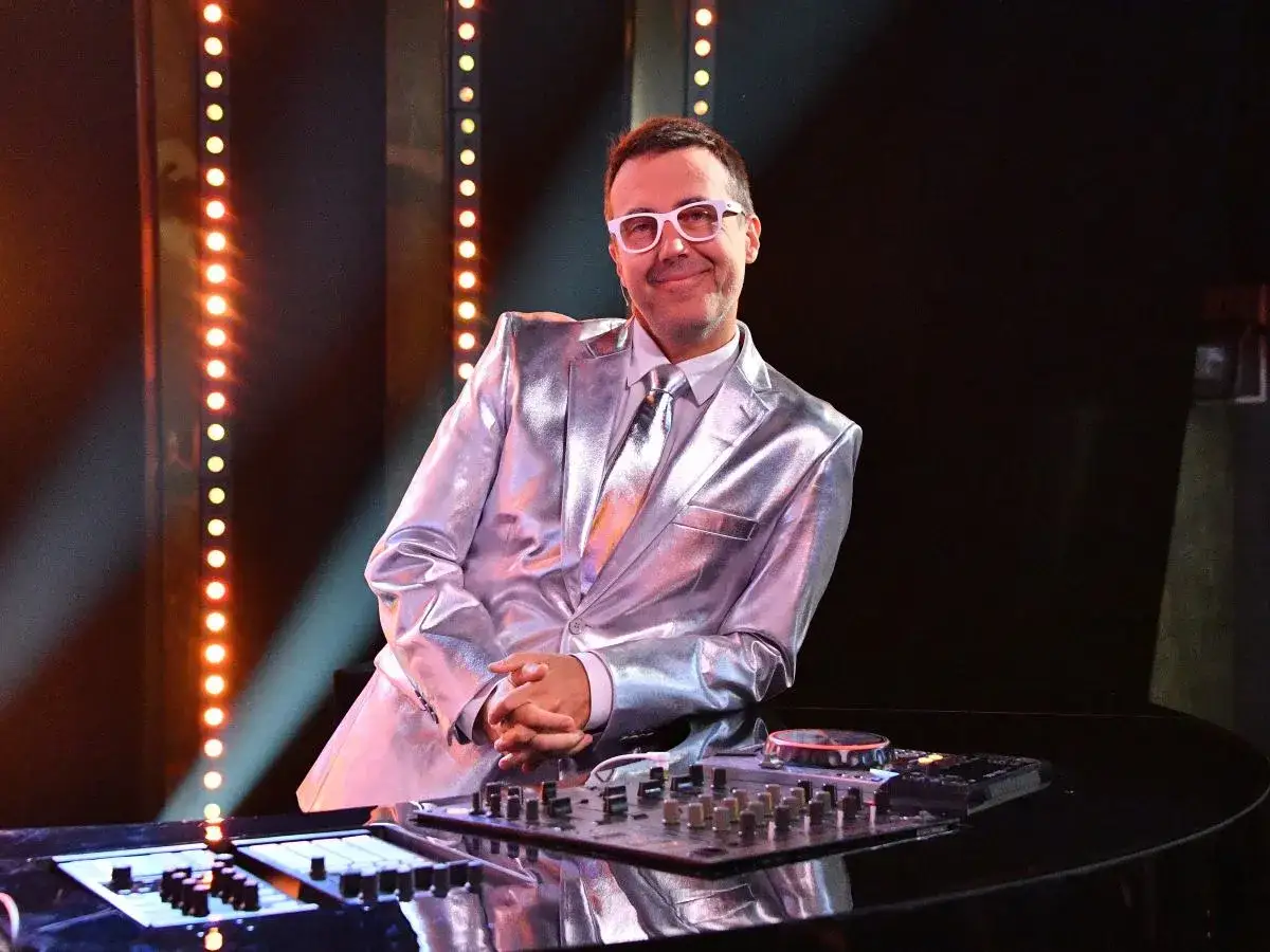 DJ w błyszczącym garniturze, gotowy do zabawy w