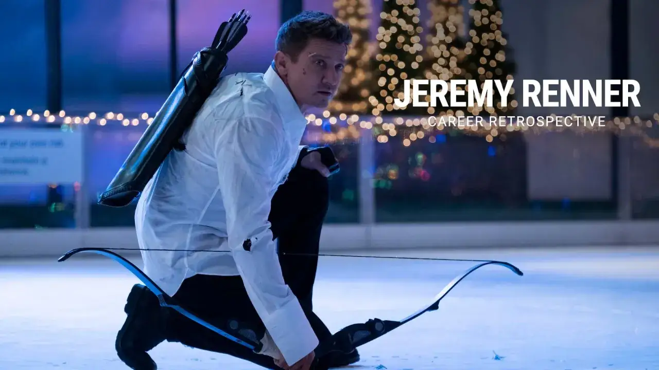 Jeremy Renner w roli Hawkeye'a, z łukiem i strzałami, na tle świątecznych lampek. Jego filmy, seriale i programy to bogata kariera.